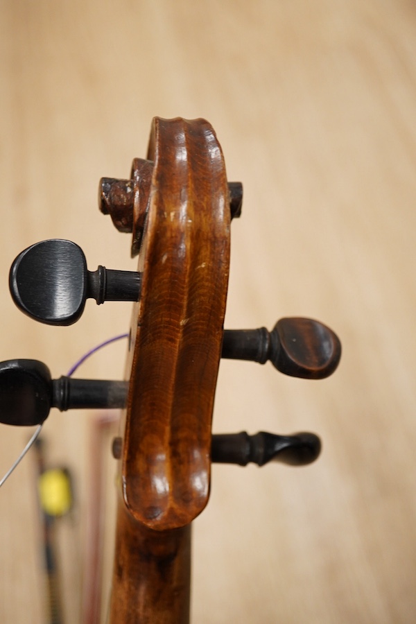 A late 19th century German violin, body 35cm long, and two bows. Condition - poor to fair.